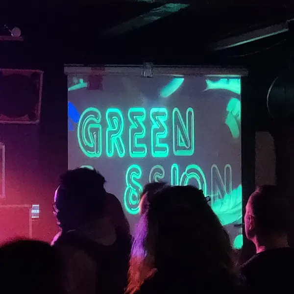 Publikum foran et lærred med Green Passion-logoet projiceret op i grønt.