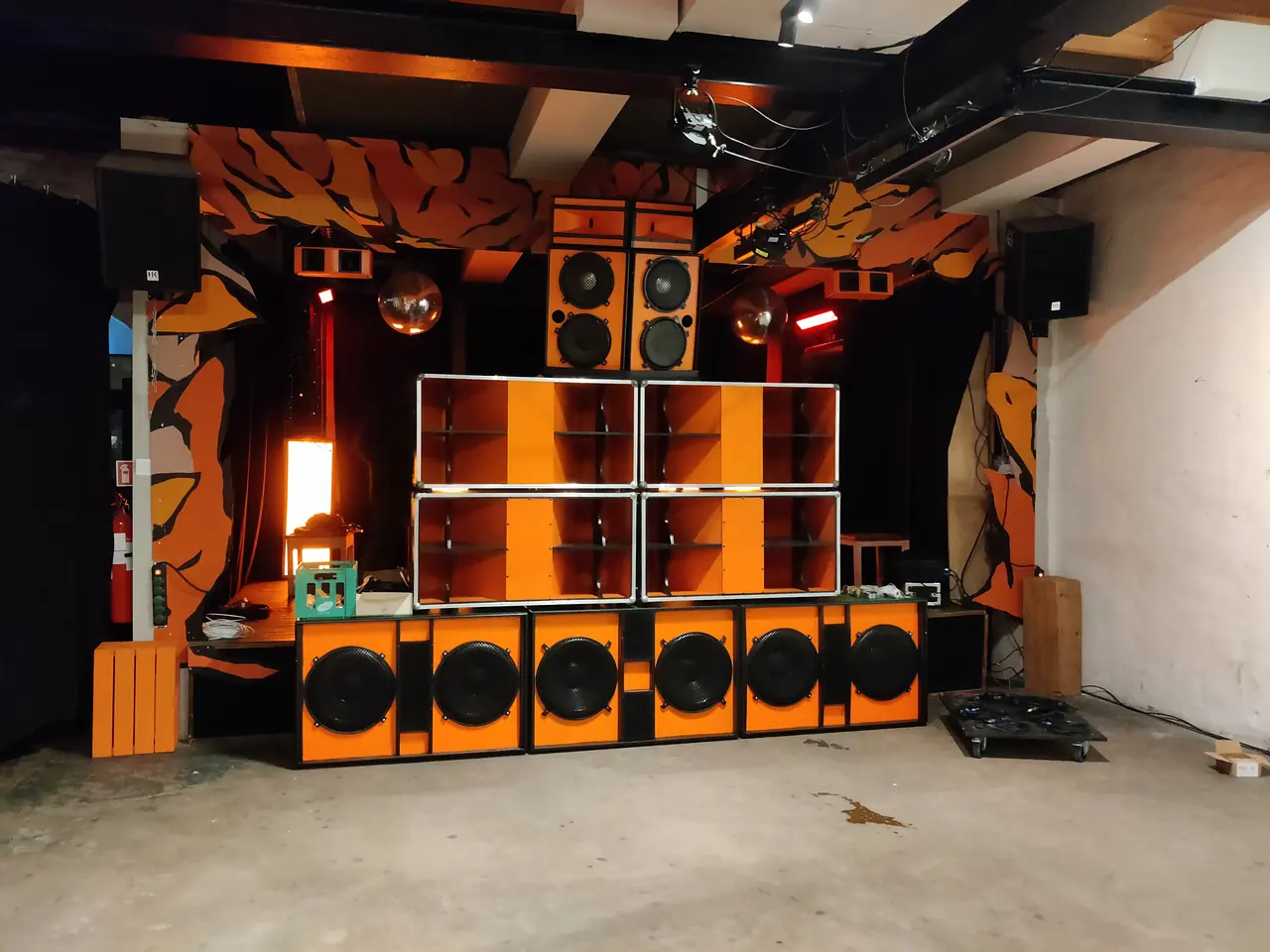 GP Elektro Sound stillet op i et rum med malede vægge: en række orange baskabinetter forrest, hornkabinetter og toppe stablet ovenpå.